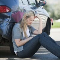 Woman Sitting On The Road After Accident Stock Photo