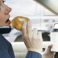 Eating While Driving Stock Photo