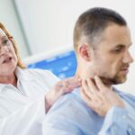 Man With Neck Pain Meeting Female Doctor Stock Photo