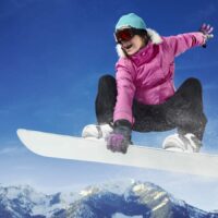 Woman Riding A Snowboard Stock Photo